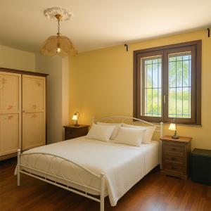 ein Schlafzimmer mit einem weißen Bett und einem Fenster in der Unterkunft Villa Ferrara Royal Resort & Spa in Coriano