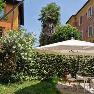 parasol i stół z krzesłami na dziedzińcu w obiekcie Minimal Chic House - Green oasis near the center with private parking & pet-friendly w Bolonii