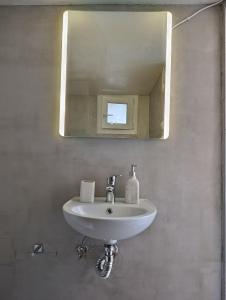 a white sink in a bathroom with a mirror at Diamond's House in Kallithea Halkidikis