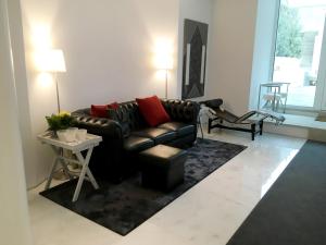 a living room with a leather couch and a table at Signature Guesthouse 2 in Porto