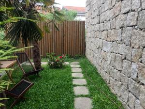 a garden with a stone wall and some chairs at Signature Guesthouse 2 in Porto