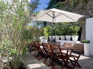 a wooden table and chairs with an umbrella at Signature Guesthouse 2 in Porto