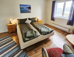 a bedroom with a large bed and a window at Våg Helgeland - Solbakken Gjestehus in Alstahaug