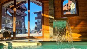 a water fountain in front of a wooden building at "Montagne Station Prapoutel" Vue Panoramique in Les Adrets