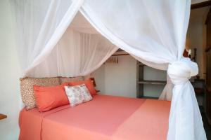 a bedroom with a bed with a canopy at Casa Canoa - Praia de Algodões in Marau