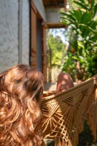 a woman sitting in a hammock with her hair at Casa Canoa - Praia de Algodões in Marau