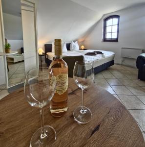 a bottle of wine and two wine glasses on a table at Fischstübchen Neeberg Apt 1 – Wald und Wiese in Krummin