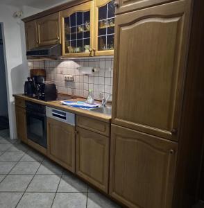 a kitchen with wooden cabinets and a sink at Fischstübchen Neeberg Apt 1 – Wald und Wiese in Krummin