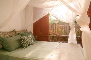 a bedroom with a bed with a canopy and a window at Casa Canoa - Praia de Algodões in Marau