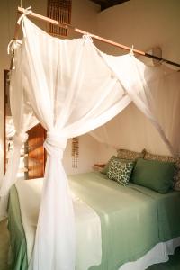 a bedroom with a bed with a canopy at Casa Canoa - Praia de Algodões in Marau