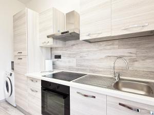 Una cocina blanca con fregadero y microondas. en 400 mt dal mare - Appena Ristrutturato, en Borghetto Santo Spirito 17 fotos más