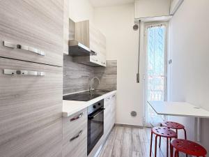una cocina con fregadero y 2 taburetes rojos en 400 mt dal mare - Appena Ristrutturato, en Borghetto Santo Spirito