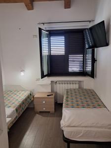 two beds in a room with a window at Villa Vera Tropea - free parking in Tropea