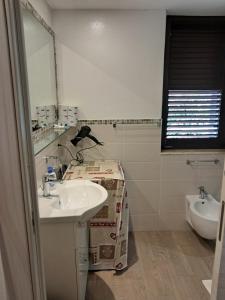 a white bathroom with a sink and a toilet at Villa Vera Tropea - free parking in Tropea +8 photos