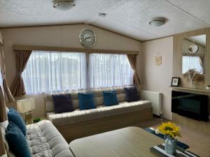 a living room with a couch and a clock on the wall at Highway in Lossiemouth