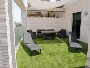 a patio with a table and chairs on a lawn at Ático centro Huelva, parking incluido in Huelva