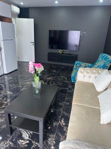 a living room with a couch and a table with flowers on it at Belek Room Voyage in Belek