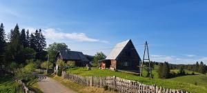a small wooden house on a hill with a fence at Domacinstvo Obradovic Nadgora in Nadgora