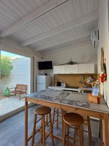 a kitchen with a large island with bar stools at Camere A Oriente II Room and Apartments in Torre dell'Orso