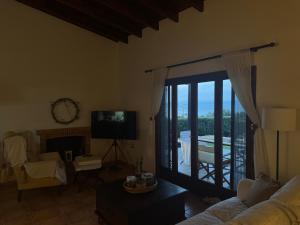 a living room with a couch and a television and a balcony at Villieta Marina in Vaia