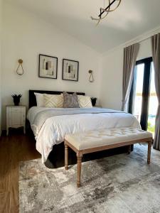 a bedroom with a large bed and a bench at Casa Milea - Vilamoura Marina in Quarteira
