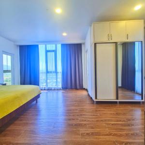 a bedroom with a bed and blue curtains at Panoramic #1 Sea Mountain View 1BR apartment Living Room, Balcony, Kitchen in Batumi