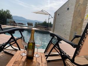 a bottle of wine sitting on a table with two glasses at Secret Villa in Vlorë