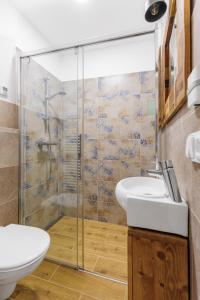 a bathroom with a glass shower and a toilet at Bob Apartmá - Resort Abertham in Abertamy