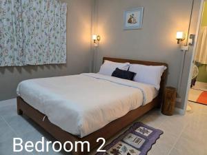 a bedroom with a large bed with two pillows at Ballachulish Rayong 2 BR in Mae Pim