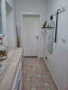 Łazienka z drzwiami i podłogą wyłożoną kafelkami w obiekcie Apartmani Mirela w Krku