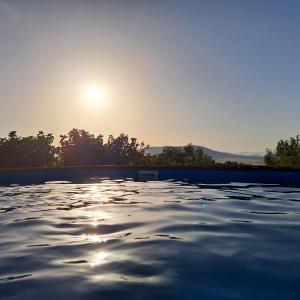 a pool with the sun setting in the background at Villa Paquita in Vallejas
