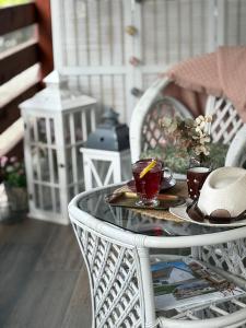 biały stół z dwiema filiżankami herbaty w obiekcie Ezüst Boróka Apartman w Egerze