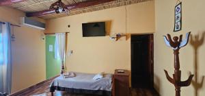 a room with a bed and a tv on the wall at Cabaña KUYAY in Purmamarca