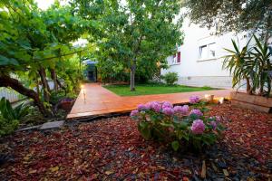 a garden with purple flowers and a wooden walkway at B side in Fažana