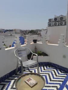 a chair on a balcony with a view of a city at Sky Blue in Tangier