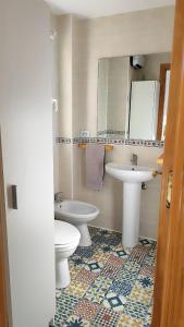 a bathroom with a sink and a toilet and a mirror at Estudio vistas al Veleta Parking Gratis in Monachil
