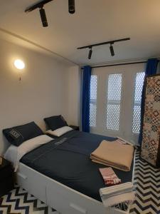 a bedroom with a large bed with blue curtains at Sky Blue in Tangier