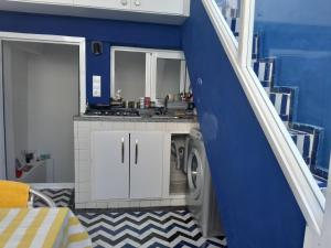 a kitchen with a washing machine in a blue wall at Sky Blue in Tangier