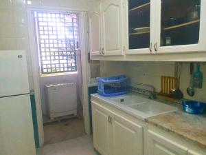 a kitchen with white cabinets and a sink and a window at S1 Moderne à Ennasr 2 - Vue Jardin, Fibre Optique & Proche de Tout in Ariana +5 photos