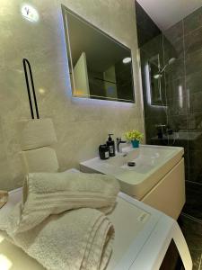 biała łazienka z umywalką i lustrem w obiekcie Apartment Clover Sarajevo w Sarajewie