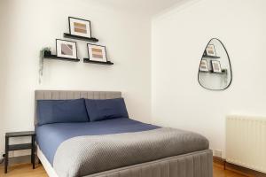 a bedroom with a bed and some pictures on the wall at Entire 3 Bedroom Home With Garden In London in Edmonton