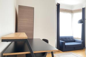 a desk and a blue chair in a room at Entire 3 Bedroom Home With Garden In London in Edmonton