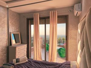 a bedroom with a bed and a large window at Ourika Luxury Villa in Ourika