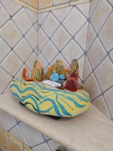 a colorful cushion with stuffed animals on a counter at 100 Passi Castelbuono Experience in Castelbuono