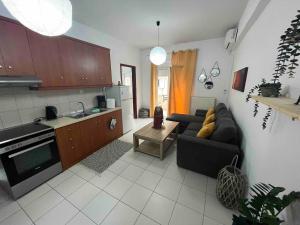 a living room with a couch and a kitchen at Cozy apartment in Thérissos