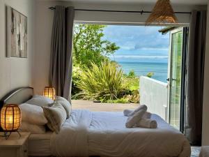Un dormitorio con una cama con vista al mar. en Beachfront Luxury Edwardian Retreat With Sea View, en Combe Martin