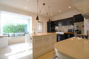 una cocina con armarios negros y una gran ventana en Beachfront Luxury Edwardian Retreat With Sea View, en Combe Martin
