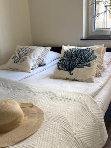 two beds with pillows and a hat on top of them at Karwia Marina Apartamenty in Karwia