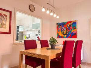a dining room with a wooden table and red chairs at Stunning Villa in Meloneras, Maspalomas in Maspalomas