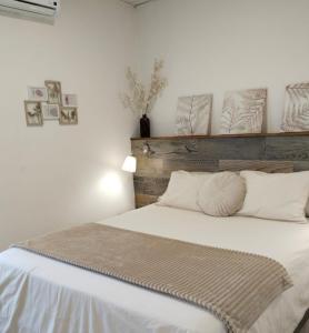 a bedroom with a white bed with a wooden headboard at GELVESTURIST 2 Free parking in Gelves
